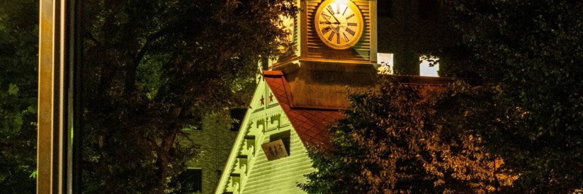 a clock tower in the middle of a city at night