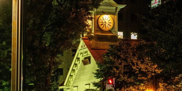 a clock tower in the middle of a city at night