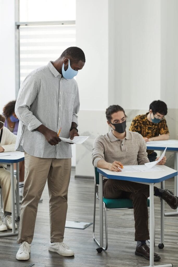 pexels photo 6684337 1 Students and teacher in masks during a classroom exam amid COVID-19 precautions.