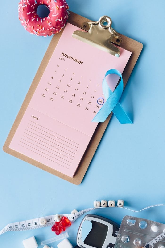 Home Creative flat lay featuring diabetes awareness symbols including a calendar, ribbon, and glucose meter.