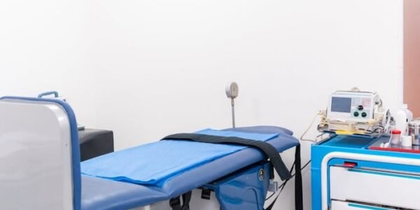 Clean and well-equipped hospital examination room with blue medical equipment and diagnostic devices.